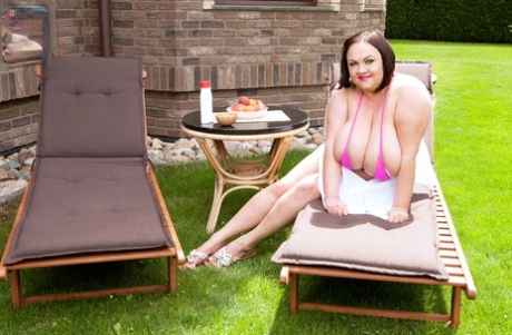 BBW Natascha Romanova perfumes her giant tits on a porch-style chair.