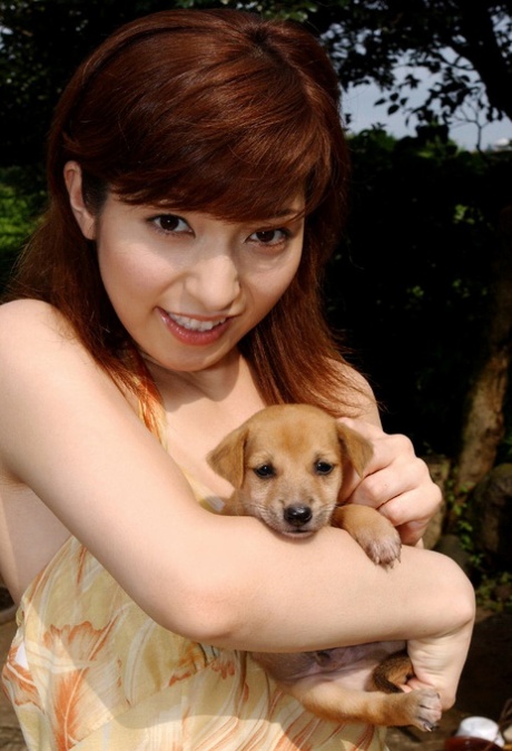 Japanese redhead named An Naba is seen in a complete numbness as she plays with puppies.