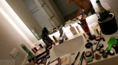 An amateur model takes pictures of herself in a mirror, both naked and non-nude, as shown in the picture.