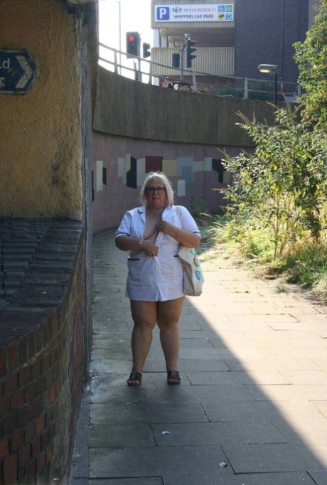 Obese: Fat old nurse Lexie Cummings bares herself on the sidewalk during her walk for hours.