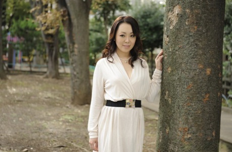 In a white dress, Yuna Yamami, an elegant Japanese woman, looks nude outside.