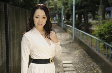 Non-nude image: High-heeled Japanese woman Yuna Yamami, left, dresses in a white dress outside in a photoshoot.