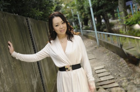 In a white dress, fashionable Japanese woman Yuna Yamami looks nude while outdoors.