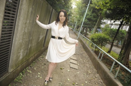 A non-nude image of a stylish Japanese woman is Yuna Yamami, who dresses in a white dress while out.