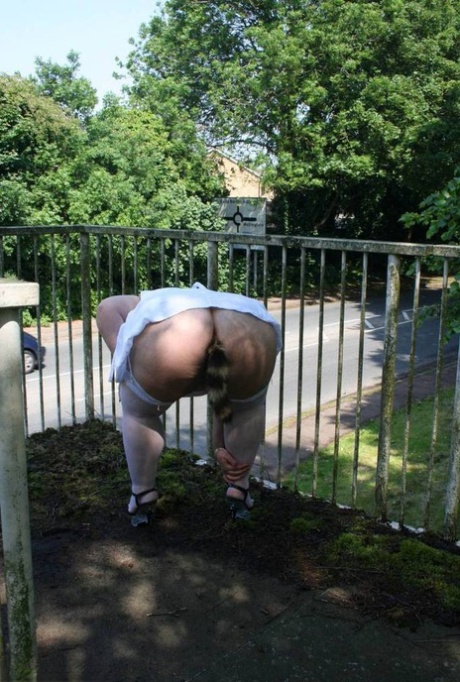 While passing a pedestrian overpass, Lexie Cummings, a fat blonde, exposes herself.