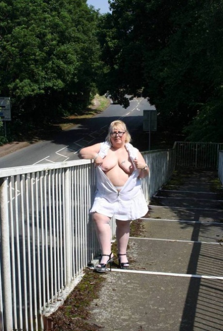 In a pedestrian overpass, Lexie Cummings exposes herself while being overweight and blonde.