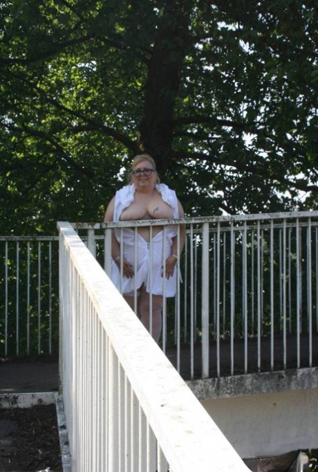 Crossing: Lexie Cummings, who is a fat blonde, shows off while crossing a pedestrian overpass with her hands on the pavement.