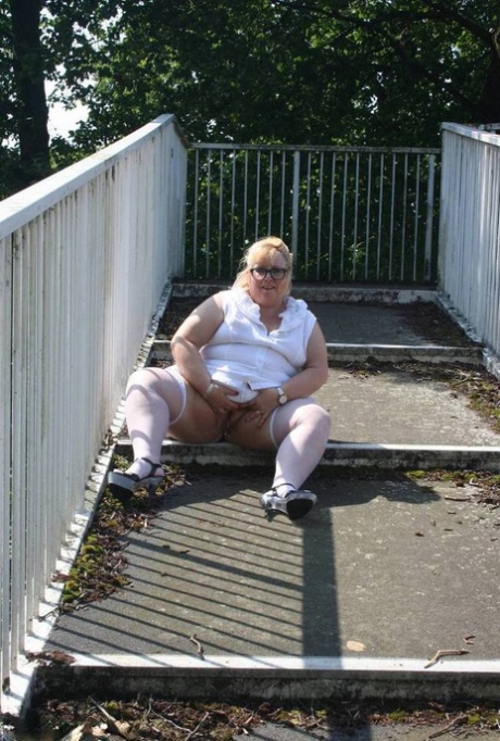 Exposed: Fat blonde Lexie Cummings poses for pictures while crossing a pedestrian overpass with her hands on the ground beneath them.