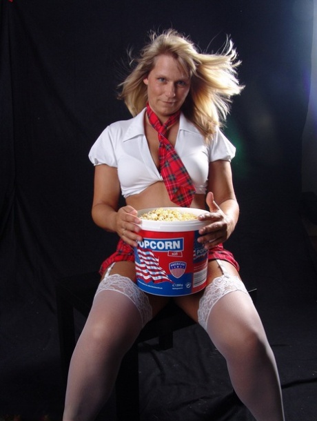 The amateur sweet Susi, who is blonde, goes completely naked while enjoying a tub of popcorn.