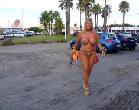 In a nude resort, the busty blonde shows off her body in mostly clothes.