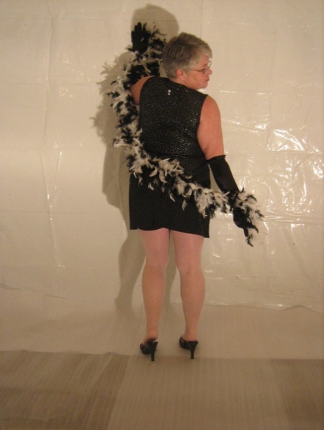 In a strip show, the silver-haired granny known as the Girdle Goddess wears long black gloves.