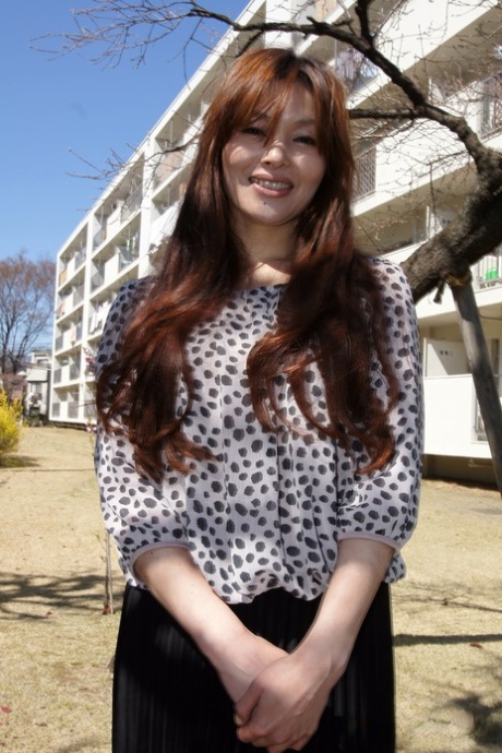 In a non-nude image, Japanese model MILF Hitomi Kano beams with a pleasant smile.