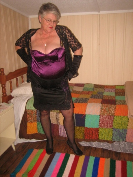 The greasy-looking Girdle Goddess, who is old, gets naked in her bedroom while wearing black gloves.