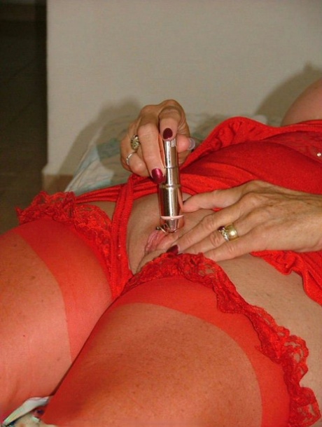 After self-pleasuring, a young woman in red loose-leaf clothing and woolen slippers sucking on her vibrator.