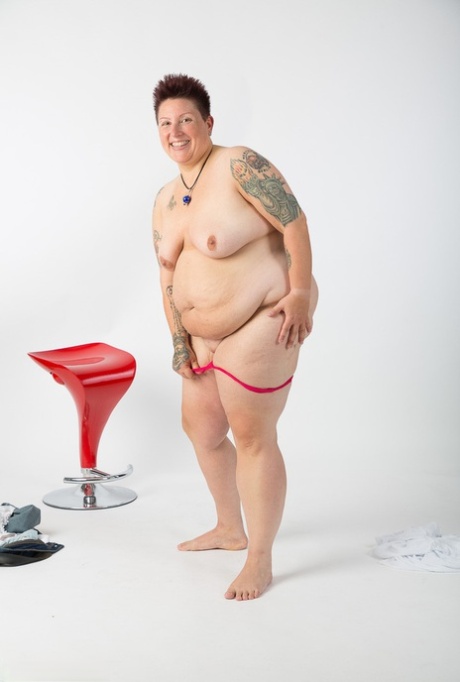 Obese amateur Tattoo Girl sits on a stool after getting totally naked