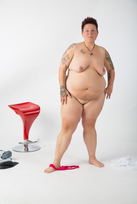 After being stripped down to her bare hands, an elderly Tattoo Girl who is not a professional takes it upon herself to sit on a stool.