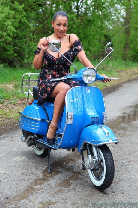 Danica Collins, a mature female, exhibits large tits and twats on a scooter.