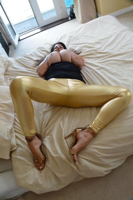 Lu Lu Lush, a middle-aged British woman, showcases her massive breasts in gold pants.