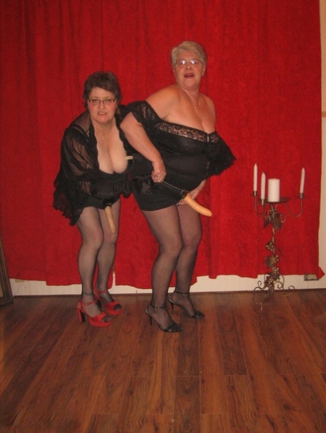 A lesbian girlfriend and her Big titted granny Girdle Goddess wear strapon cocks.