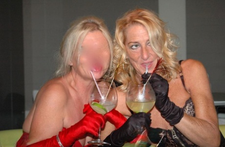 Mature lesbians tongue kiss while getting drunk in lingerie and long gloves