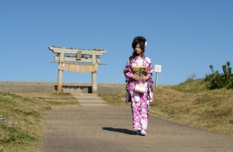 An Asian model named Chiaki walks along the beach and surrounding area in a kimono.