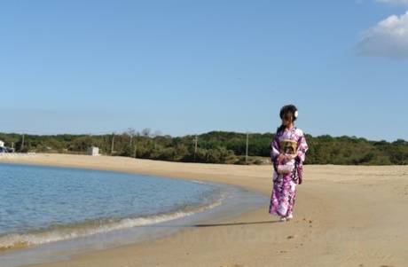 Chiaki, an Asian model dressed in a kimono, walks by the beach and surrounding area.