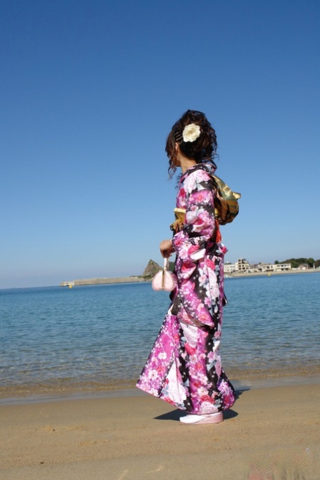 Chinese model Chiaki, who is Asian in dress and wearing a kimono, walks along the beach and surrounding area.