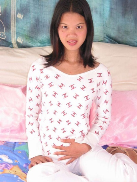 A small, Asian female cups a firm pussy before taking her dilta.