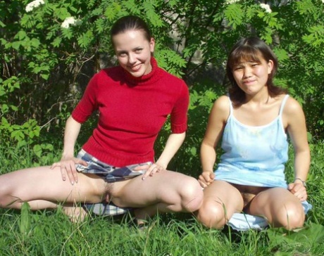 After playing in a park with their tits and asses, lesbian amateurs start to show off their legs by petting their pussies.