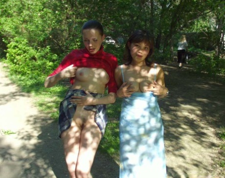 In a park, lesbian amateurs show off their tits and asses before licking their pussies.