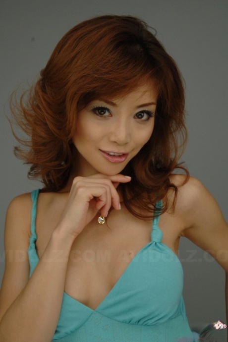 Japanese redhead: Akane Hotaru, left in a long dress, smiles as he models the look.