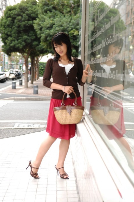 The downtown area sees Mio Kanna, a Japanese beauty, dressed in a knee-length skirt for a stroll.