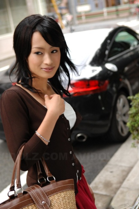 Japanese beauty Mio Kanna flaunts her knee-length skirt as she walks through the downtown area.