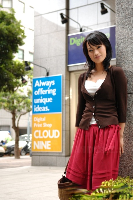 Walking through the downtown area, Mio Kanna from Japan wears a knee-length skirt.