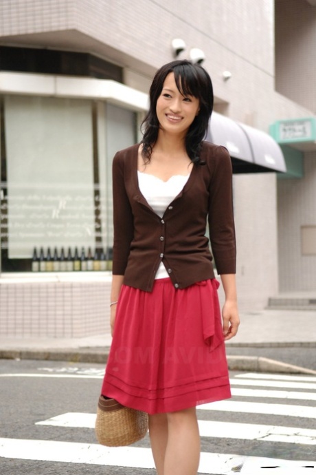 Mio Kanna, renowned Japanese actress, walks through the downtown area wearing an ankle-length skirt.