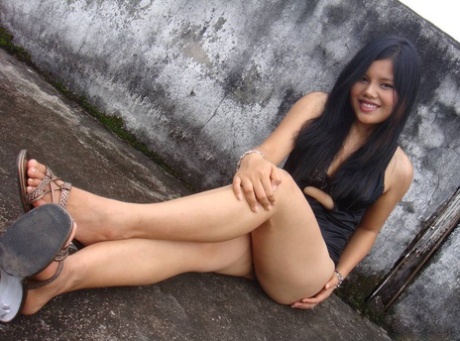 In a non-nude picture, the Filipino girl wearing only her legs poses in a black dress.