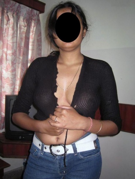 The Indian MILF wears blue jeans and displays her natural tits.