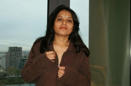 Indian woman: Kavya Sharma, pictured left, releases her natural tits from a sweater.