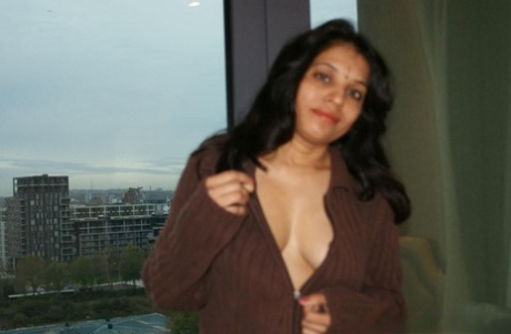 The natural tits of Kavya Sharma, an Indian woman, are released from her sweater.