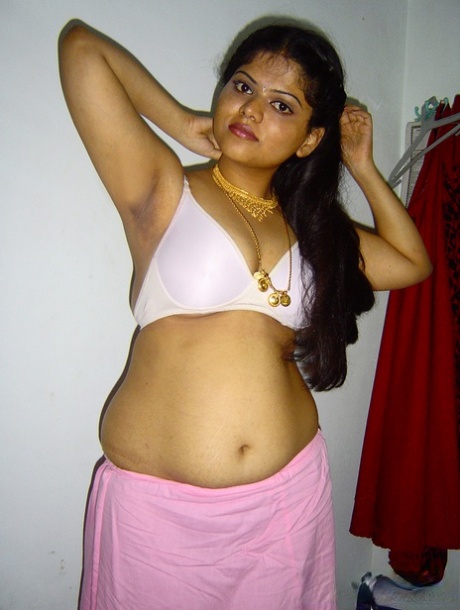 In her solo act, Neha, a plump Indian girl, becomes fully naked on her bed.