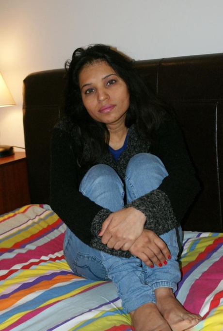 Kavya Sharma, an Indian woman, seizes a natural breast after disrobing to pleasure.