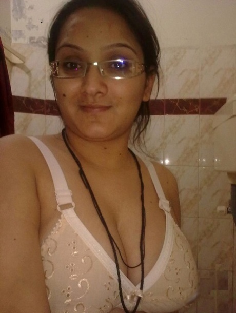 An overweight Indian student models her nude belly with a brassiere.
