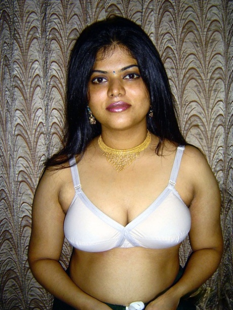 Neha, an Indian girl with a chubby appearance, releases her breasts from the white brassiere.