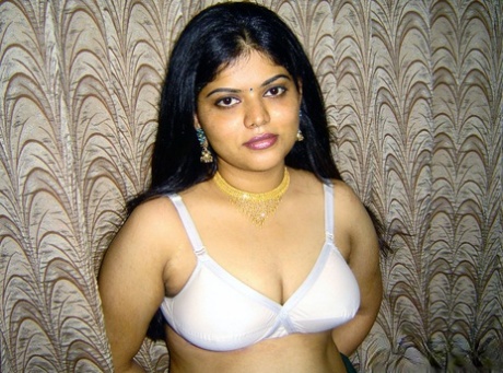 Neha, the slender Indian girl, releases her breasts from the white brassiere.