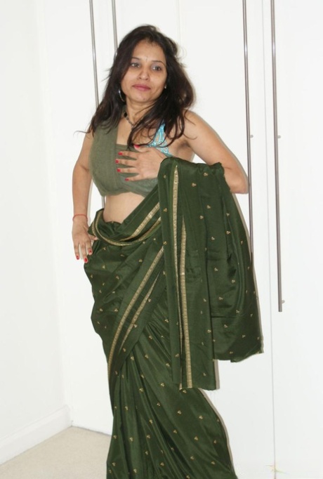 In a playful manner, MILF Kavya Sharma, an Indian, exposes herself to naked display.