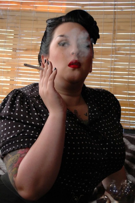 Kerosene instills a reddish-loud image of a fully clothed, overweight woman smoking cigarettes while she wraps her face around her red lips