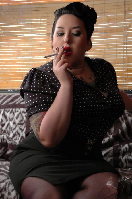 The woman who is fully clothed and fat, with Kerosene in her pocket around her red lips, smokes from a smoking cigar.