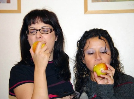 As they snack on fruit, brunette lesbians remove their clothing and take off the clothes.