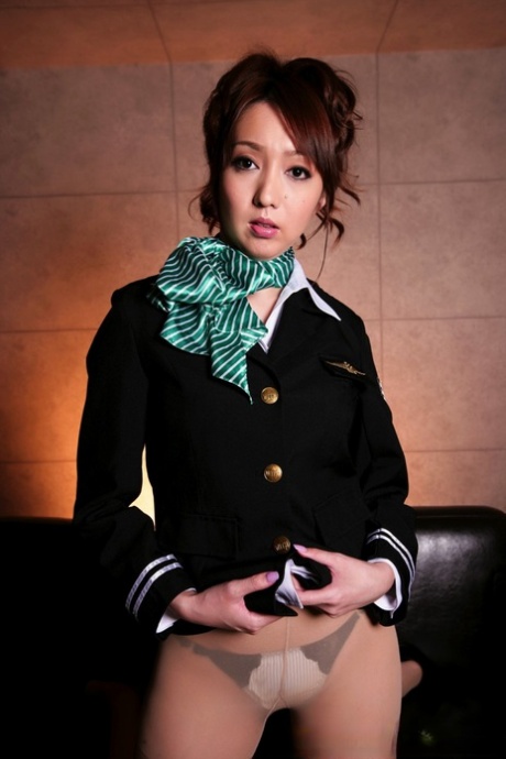 The beautiful, Japanese girl is seen with her breasts bared in the pilot's uniform.