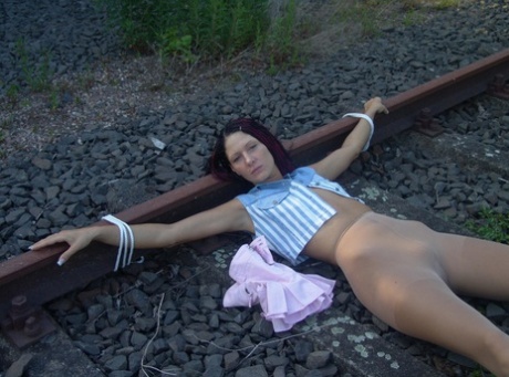 Having her water bottle removed after being tied to train tracks, the brunette girl has had it taken off.